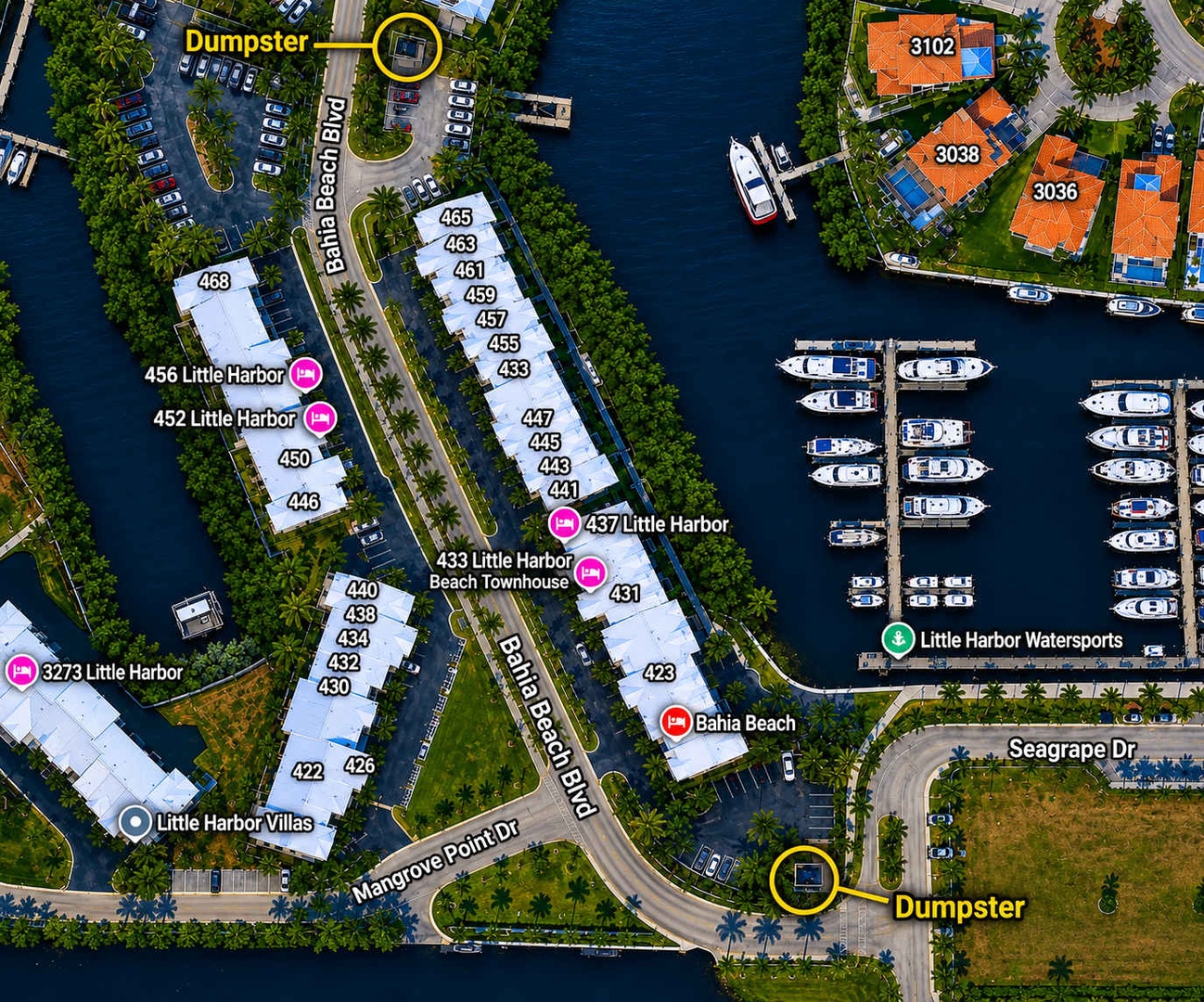Aerial view of a waterfront community featuring residential townhomes, a marina with luxury yachts, and lush tropical landscaping along peaceful canals.