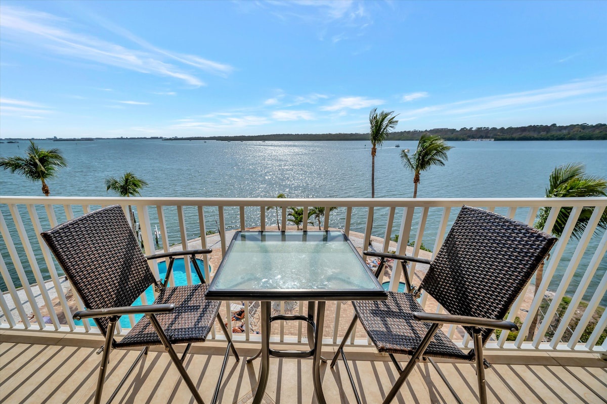Sip your morning coffee at your private waterfront table, where swaying palms frame endless water views and sunshine dances across gentle waves.