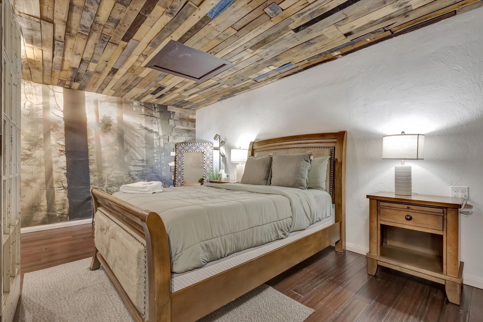 Unwind in your cozy retreat beneath stunning reclaimed wood ceilings. Soft natural light filters through sheer curtains, illuminating a restful space designed just for you.