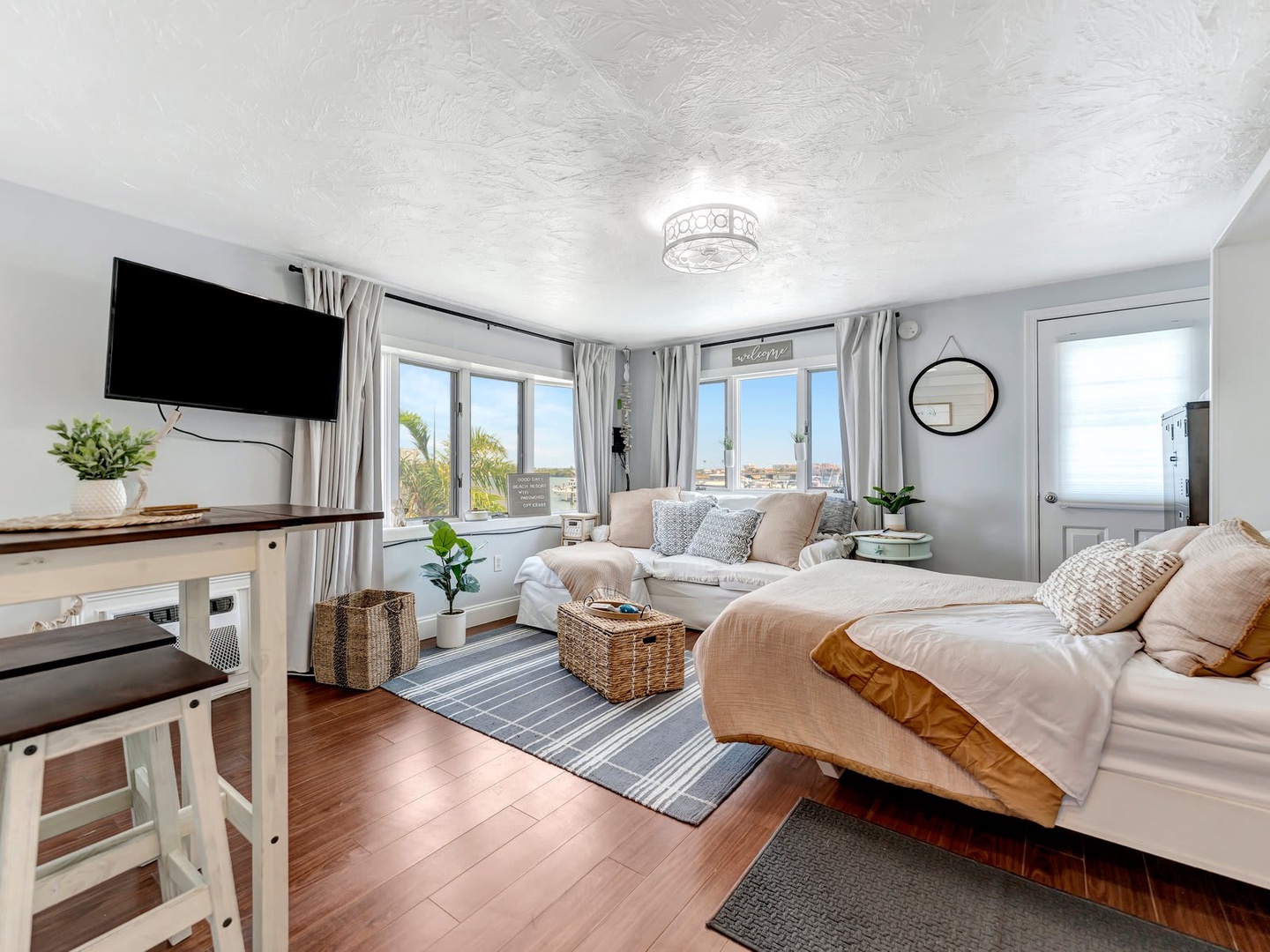 Settle into a bright, airy living room where plush sofas and coastal charm create your perfect retreat. Floor-to-ceiling windows frame stunning views, while thoughtful touches make you feel instantly at home.