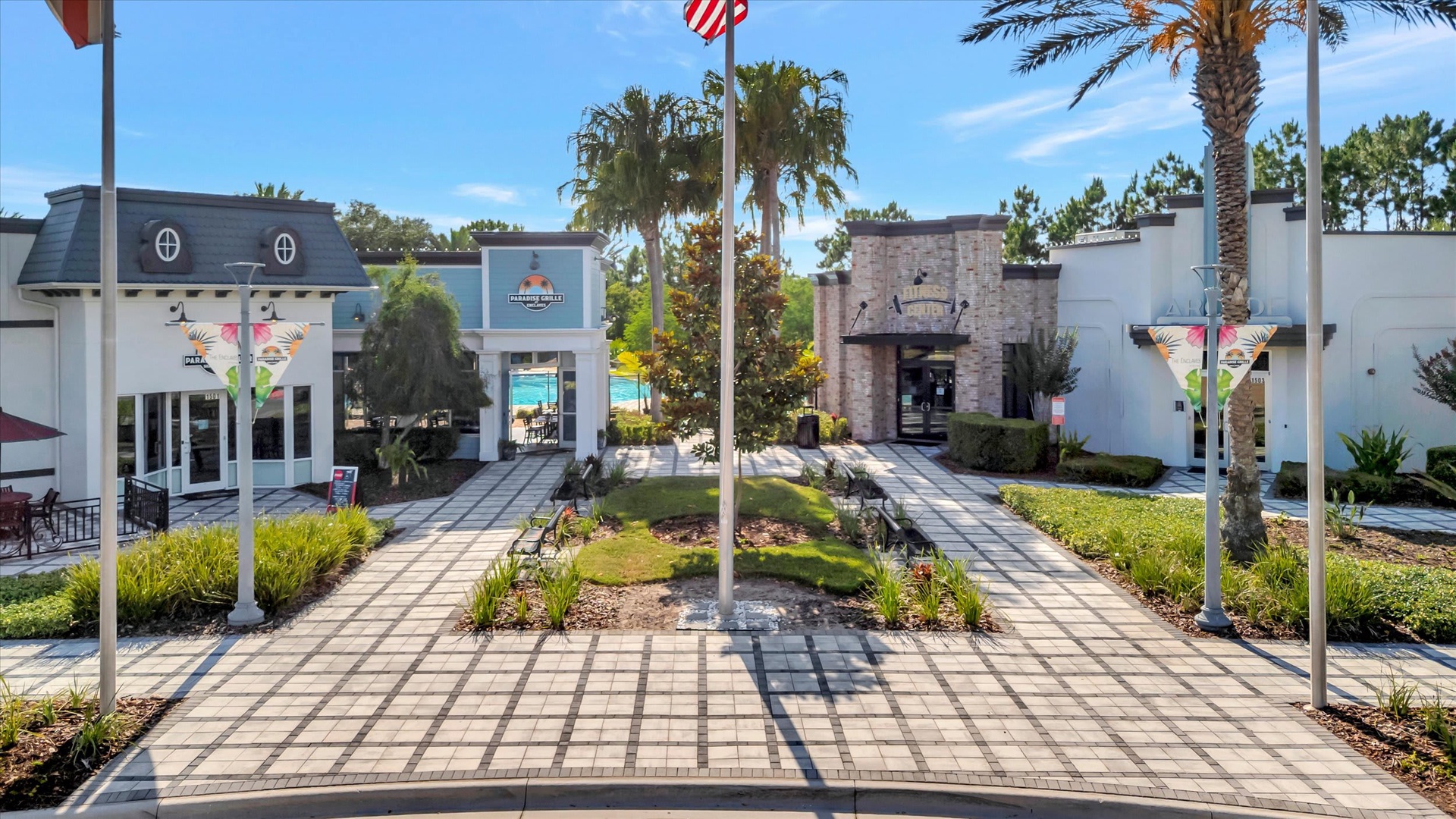 The property entrance features a landscaped courtyard with palm trees and tropical greenery, creating a welcoming arrival experience in a resort-style setting.