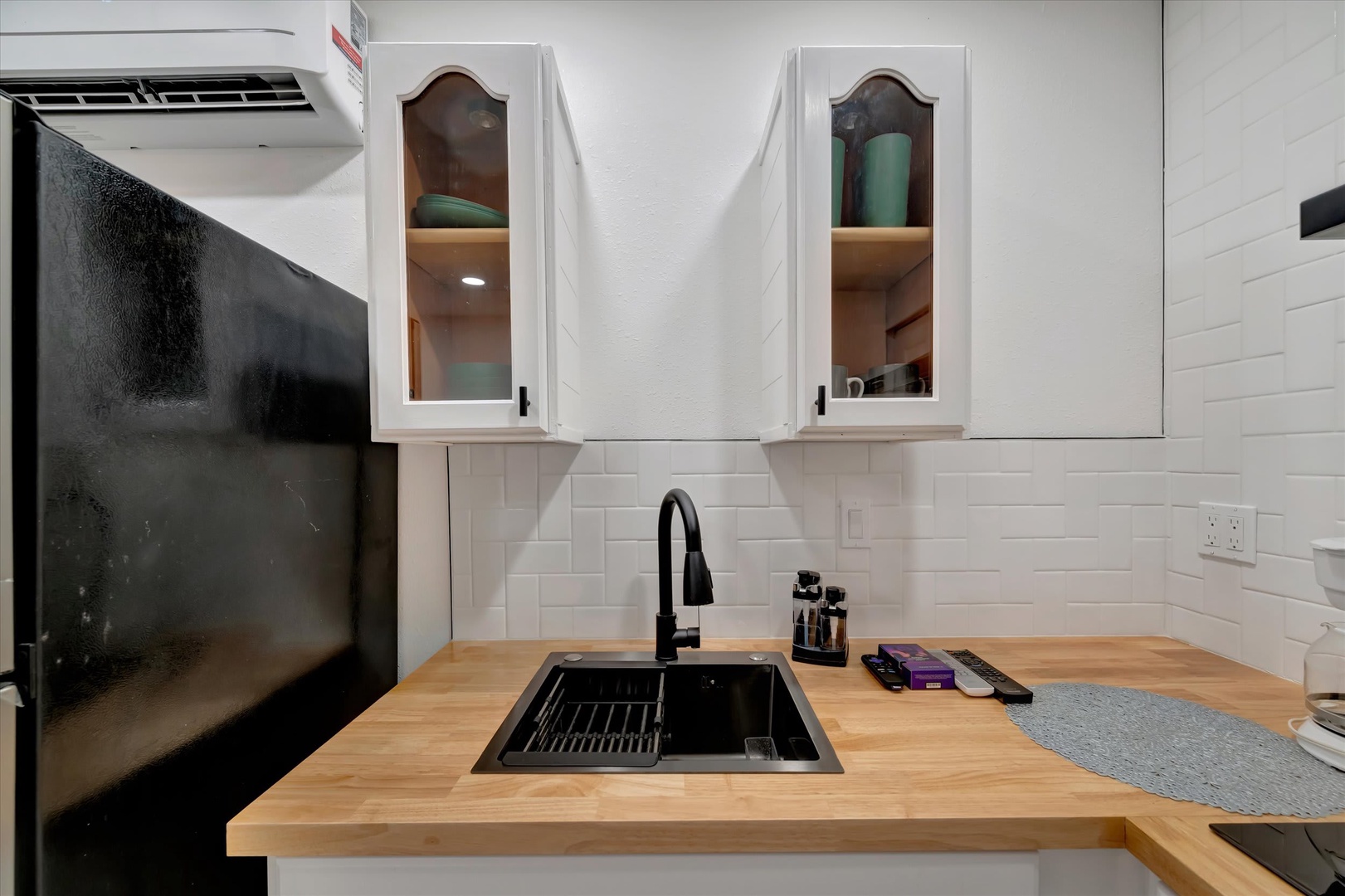 Your kitchen comes fully equipped with sleek black appliances, warm butcher block countertops, and a modern sink with pull-down faucet—ready for cooking your favorite meals in comfort.