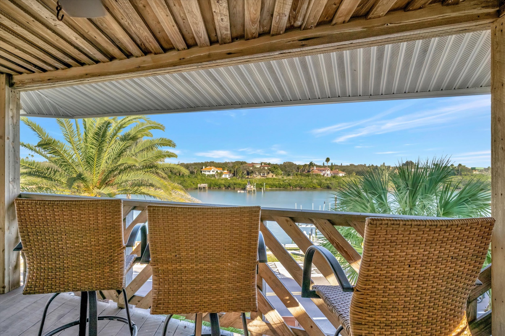 Unwind in your private covered terrace with sweeping waterfront and palm-lined views. Sink into woven wicker seating as you watch boats drift by and the sky shift colors above the peaceful shoreline.