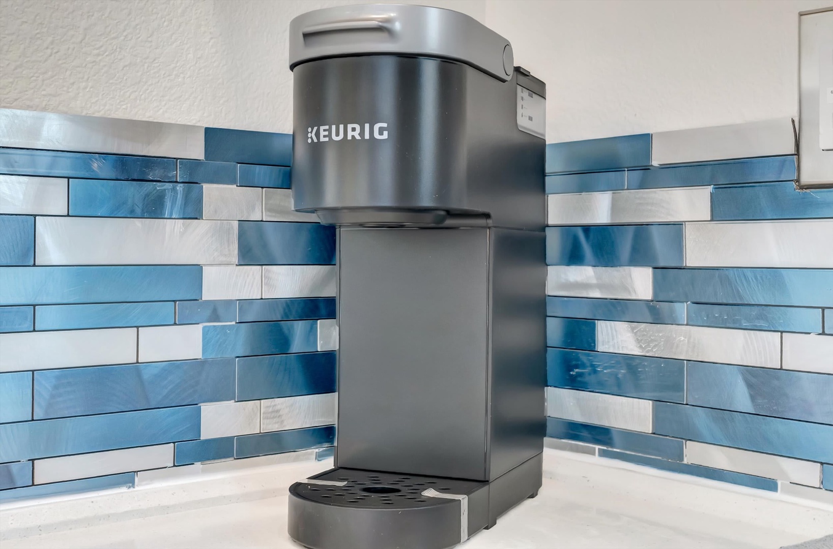 Your morning coffee awaits with this Keurig maker set against charming blue and white tile. Brew your favorite cup and start each day refreshed.