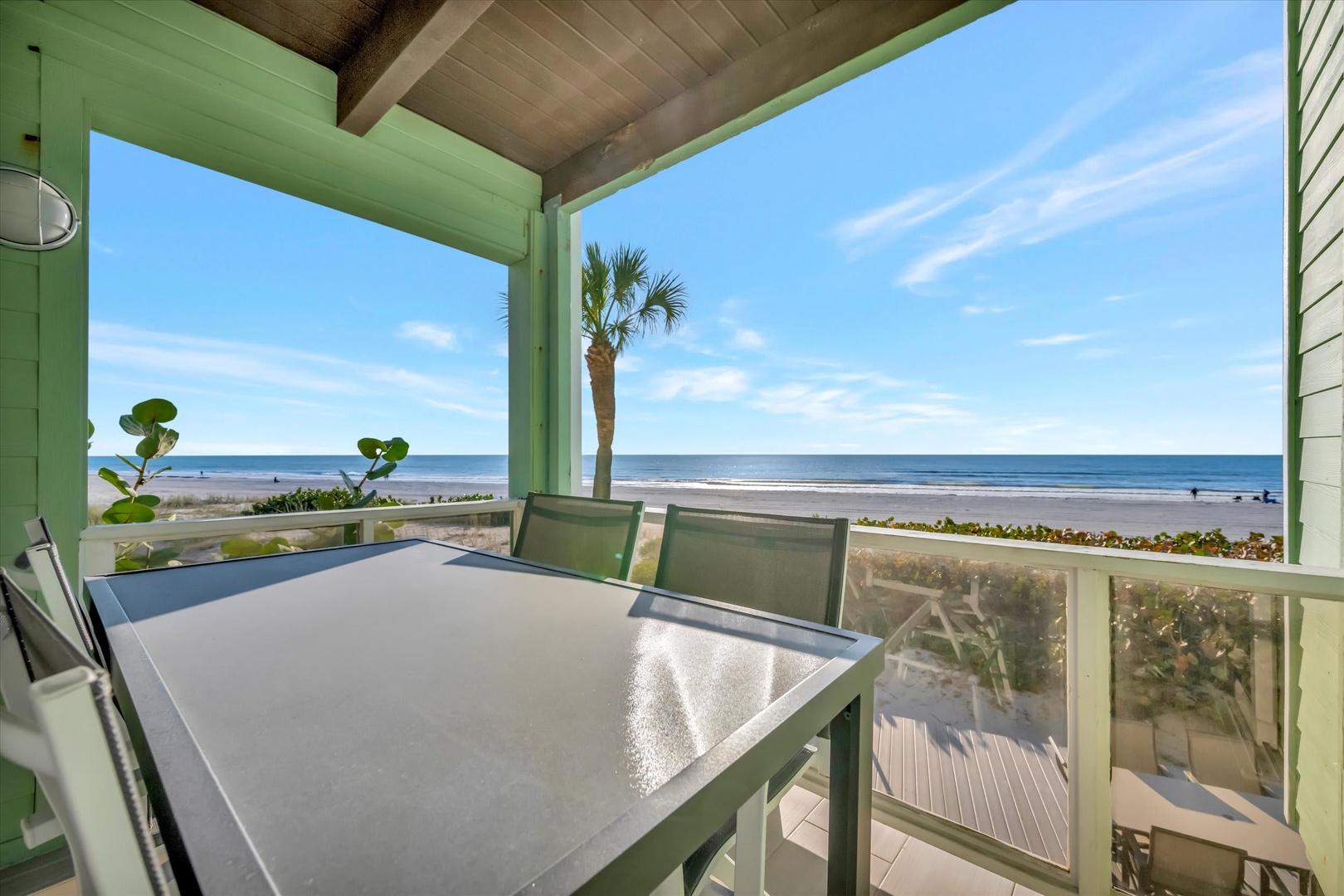 Picture yourself savoring morning coffee at this beachfront table, where palm trees frame endless ocean views and gentle waves create the perfect backdrop for your coastal retreat.