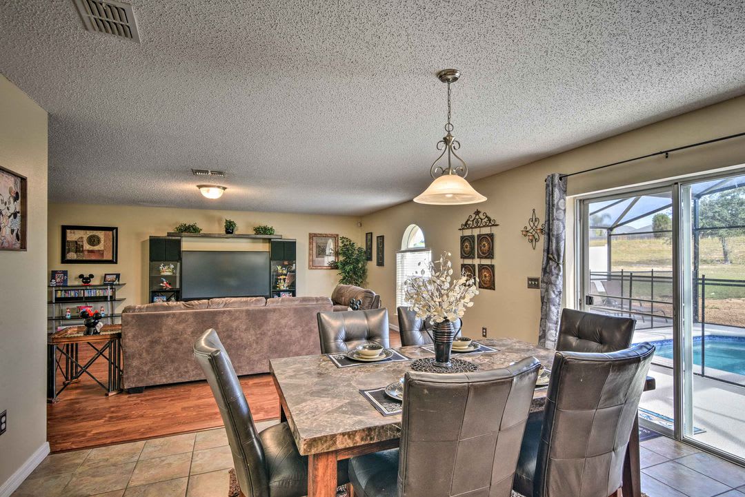 Gather around your dining table where every meal feels special, then unwind in the cozy living space with views of your private pool and screened lanai just beyond the glass doors.