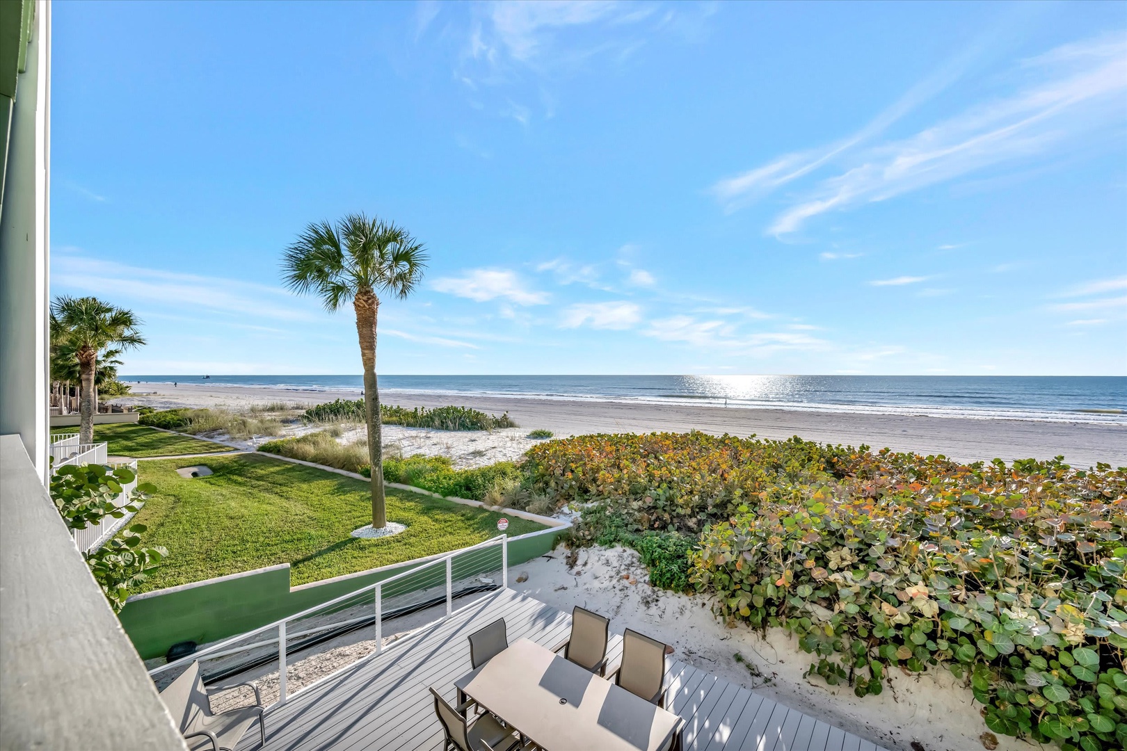 Beachfront property on Florida's Gulf Coast. The property features direct beach access, coastal landscaping with native palms and sea grapes, and sandy shoreline extending along the water's edge.