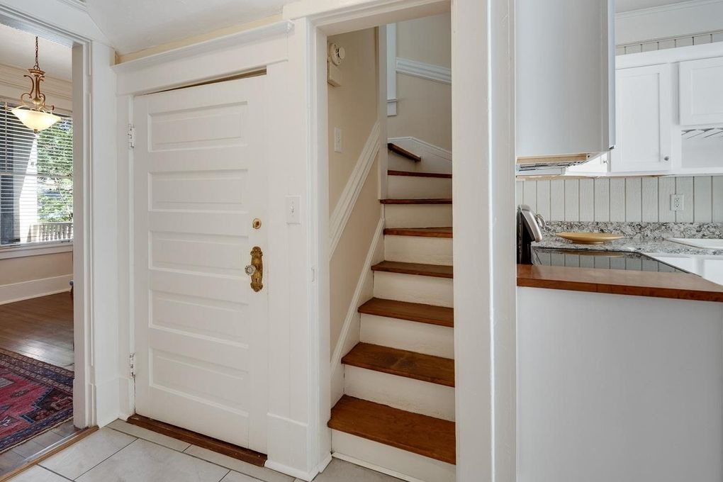 Step inside to your welcoming entry, where charming hardwood stairs lead you upward, and a bright kitchen awaits just steps away, ready for home-cooked meals.