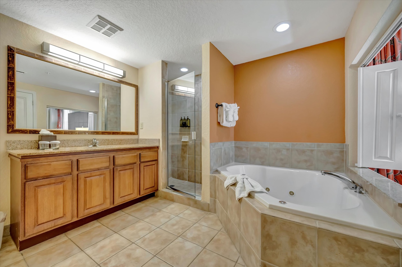 Unwind in your spacious bathroom featuring a corner jetted tub and walk-in shower—perfect for soaking away the day's adventures or refreshing before your next outing.
