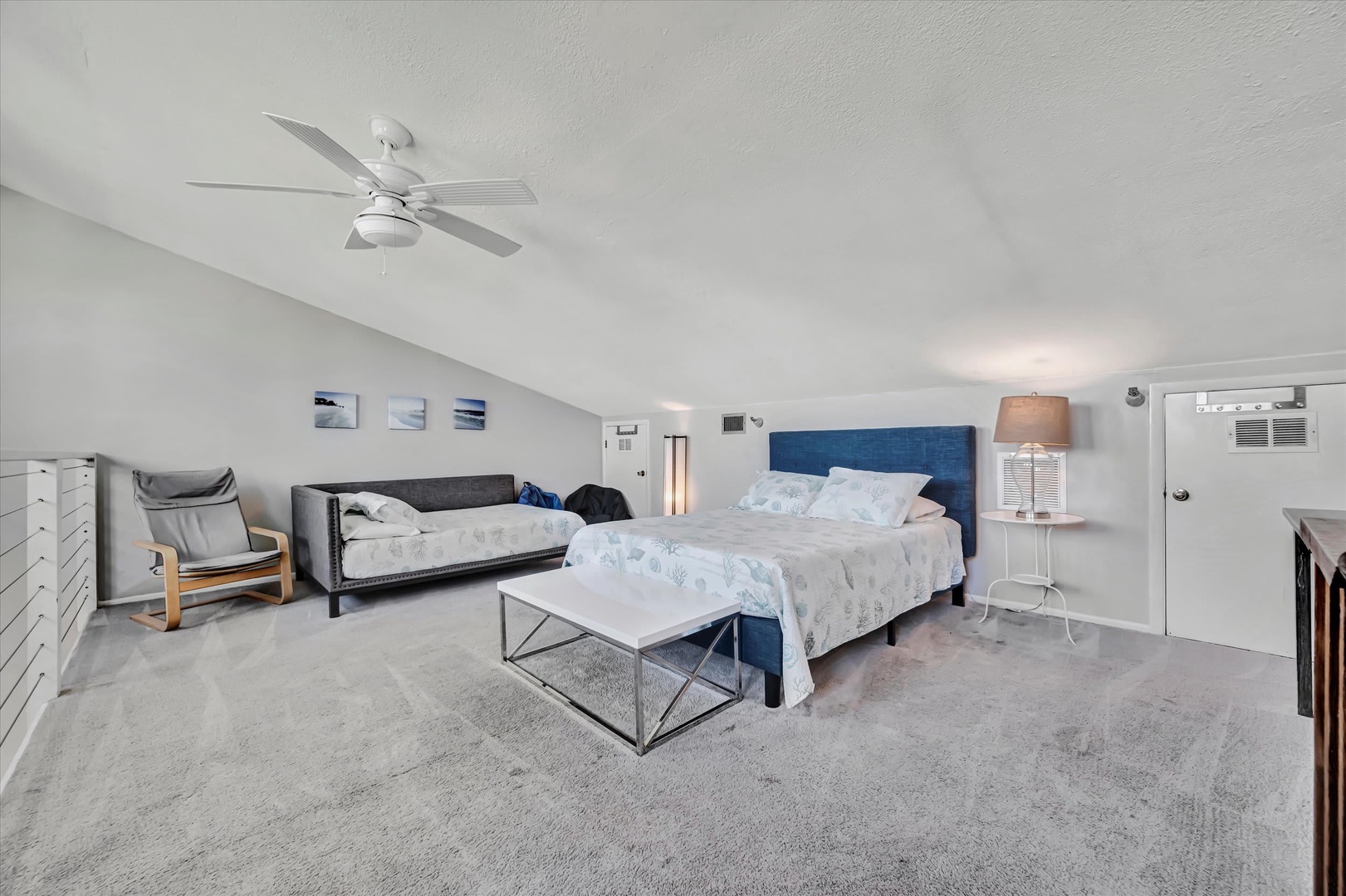 Drift off in this serene bedroom with its vaulted ceilings and soothing coastal palette. A cozy daybed offers extra space for family or friends, while soft textures and gentle lighting create your perfect sanctuary.
