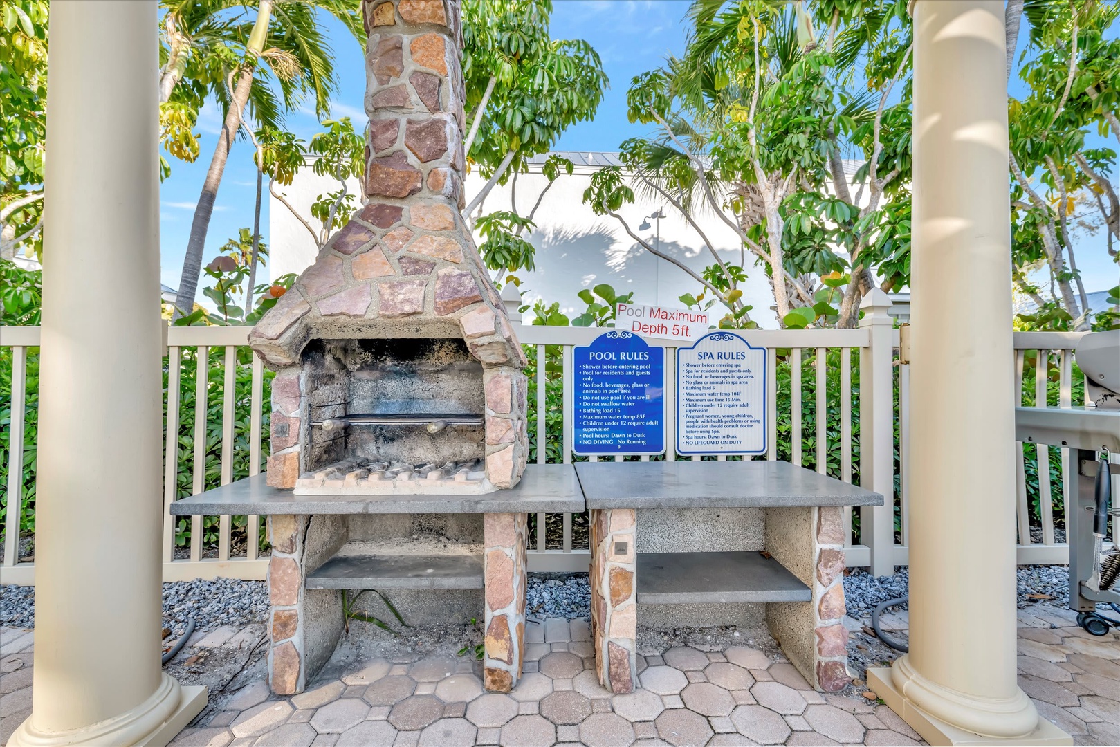 Outdoor barbecue setup ready for your poolside cookout, framed by tropical palms and a sunny Florida sky—perfect for grilling up vacation meals with family.
