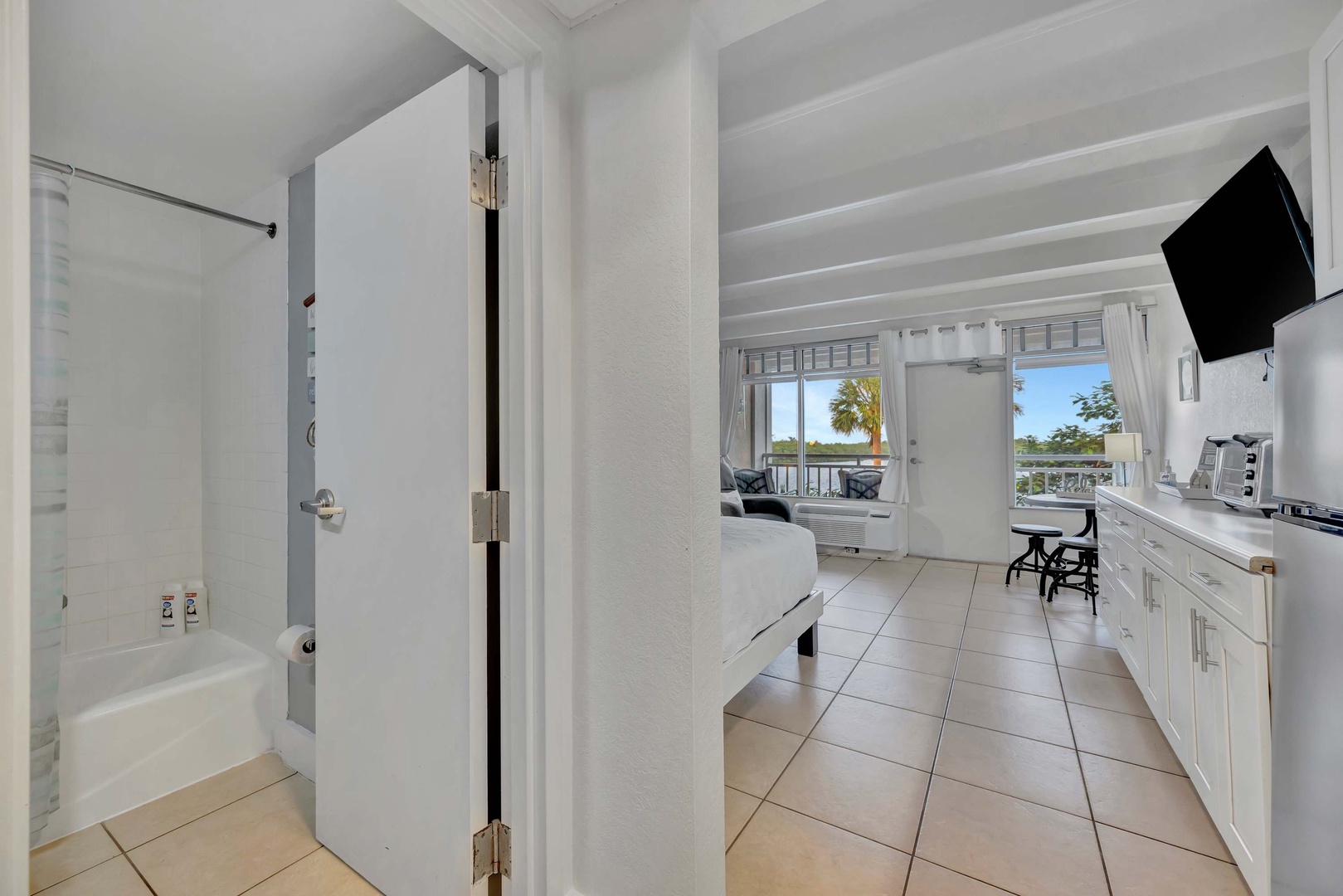 Step into your bright, beachy retreat with tile floors and crisp white finishes throughout. You'll love the glimpse of tropical palm trees and water from your window, inviting you to unwind in coastal comfort.
