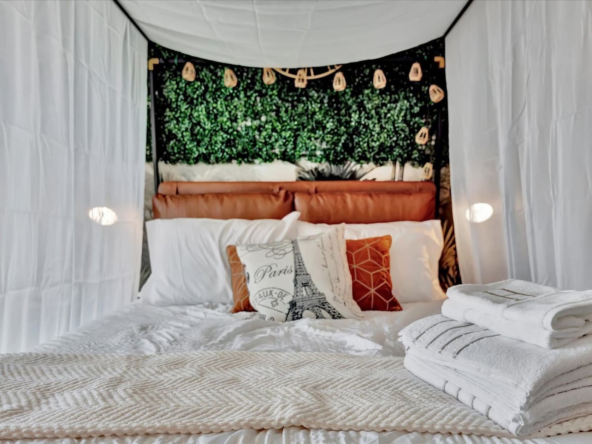 Drift off beneath the soft glow of fairy lights in your cozy retreat, where fresh linens and decorative touches create a restful haven for your getaway.