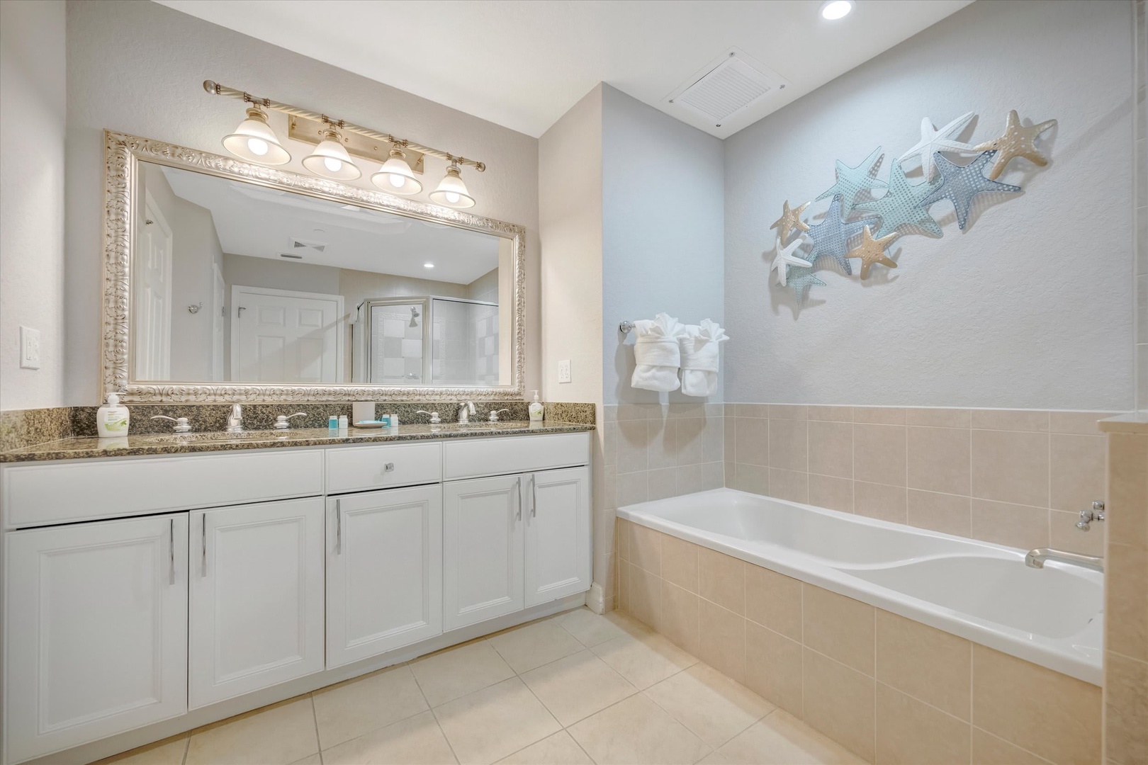 Unwind in your spa-inspired bathroom with a deep soaking tub, granite dual vanity, and coastal charm—your perfect retreat after a day of adventure.