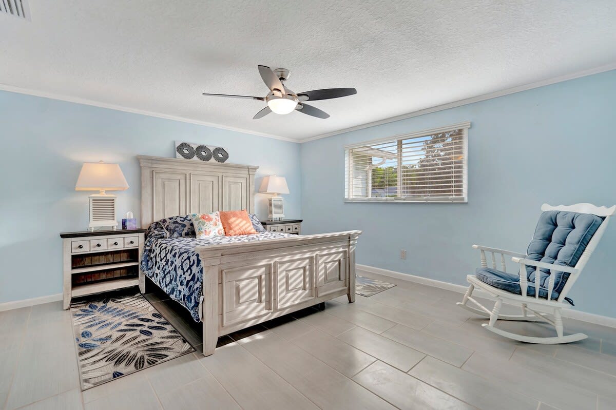 Sink into your coastal-inspired retreat with calming blue walls, elegant whitewashed furniture, and tile floors that stay cool underfoot. Relax in the rocking chair or enjoy the natural light streaming through your windows.