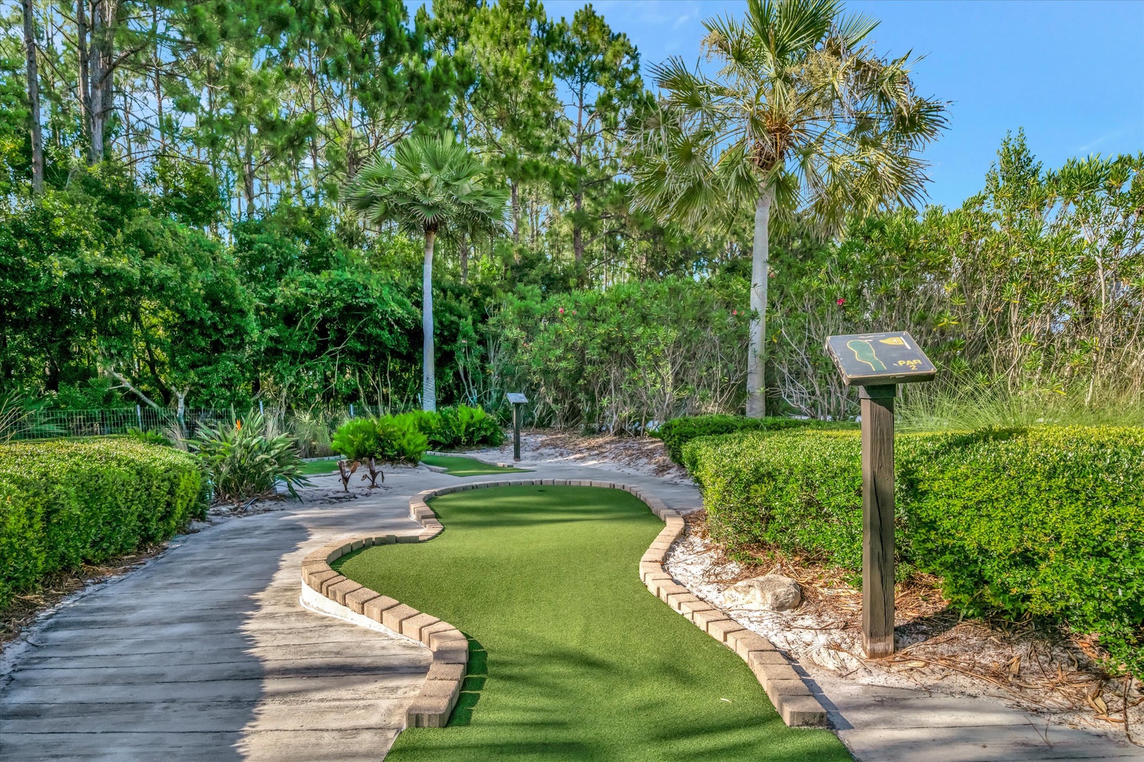 A winding miniature golf hole set within beautifully landscaped tropical grounds. Perfect for a fun afternoon challenge under sunny skies.