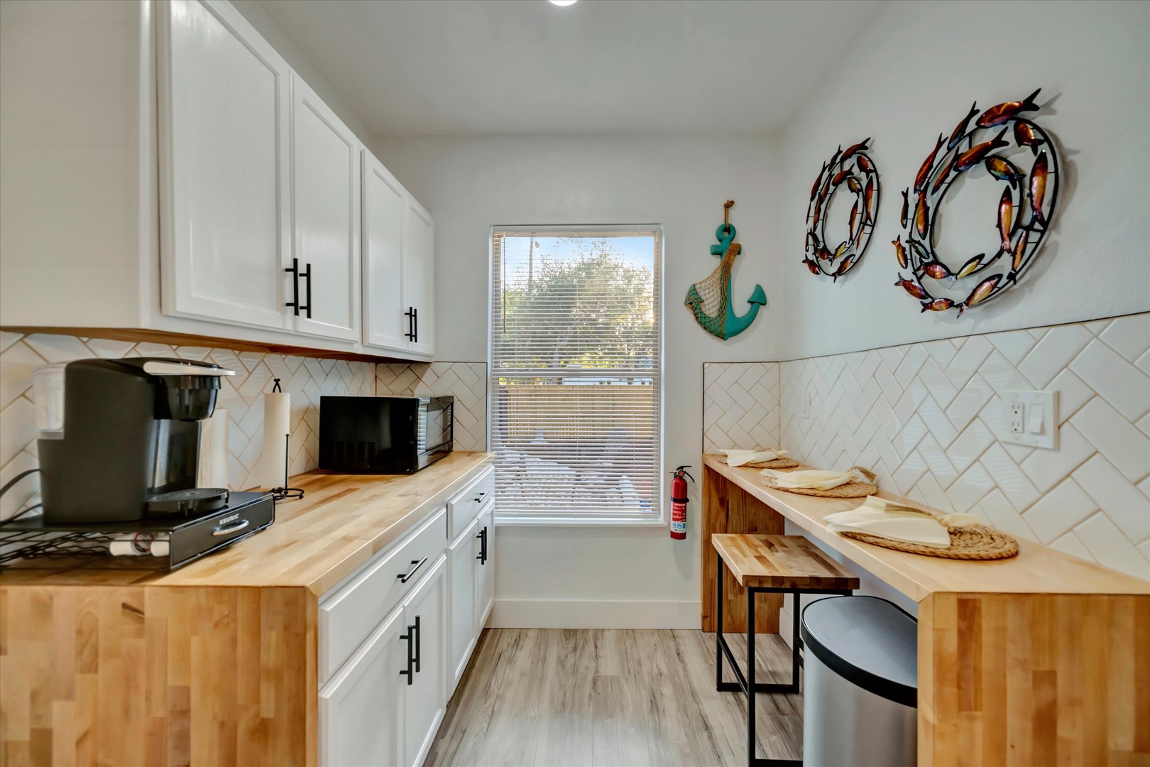 Step into your coastal-inspired kitchen, where light wood countertops and cheerful nautical décor welcome you home. Prep meals under bright natural light, with everything you need close at hand for easy beachside cooking.