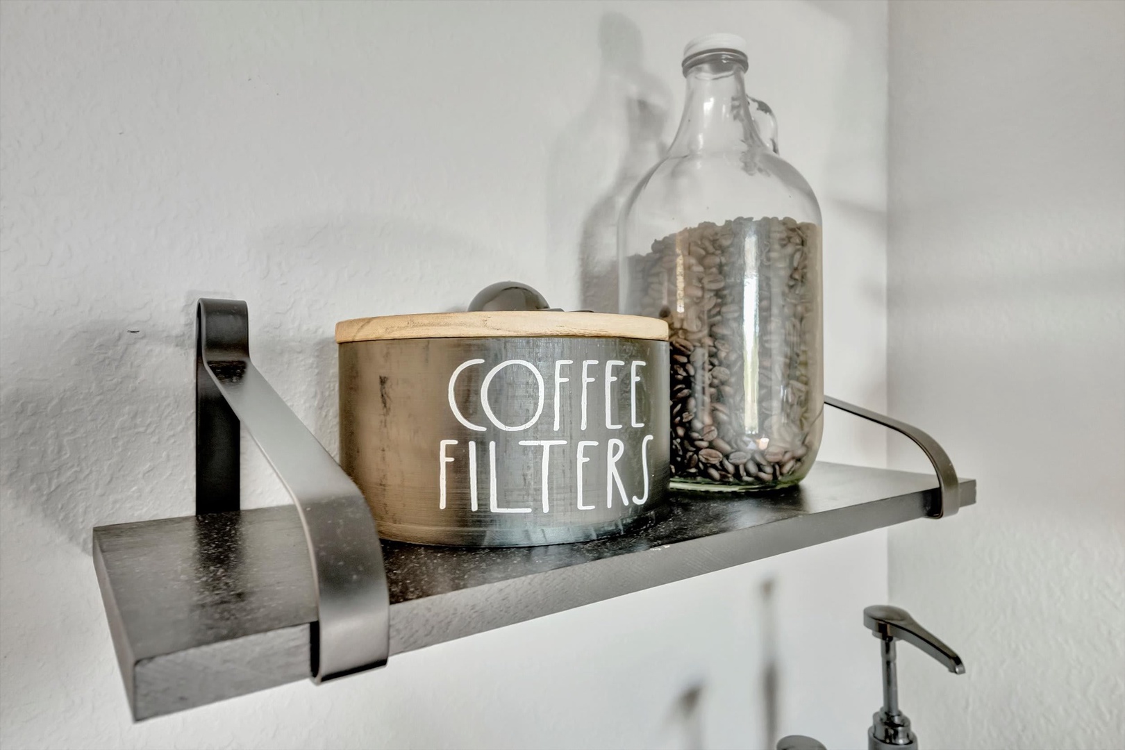 Your morning routine just got easier with everything within reach—fresh coffee beans, filters, and simple charm on a clean, modern shelf.