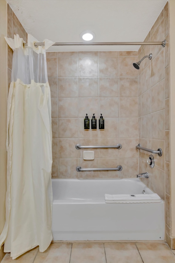 Refresh yourself in this thoughtfully designed bathroom, complete with a full tub and shower, accessibility grab bars, and soft towels ready for your comfort.