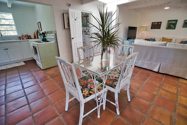 Your open-concept studio welcomes you with warm terracotta tile and an inviting layout that seamlessly blends kitchen, dining, and sleeping areas—perfect for a cozy coastal retreat.
