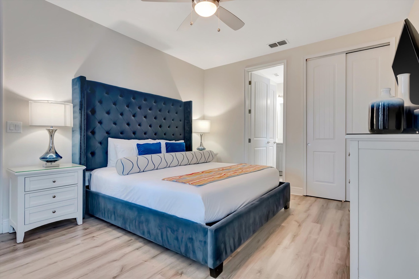 Sink into the plush tufted headboard and crisp linens after a day of exploring. Your serene retreat features a ceiling fan for comfort, stylish bedside lighting, and ample closet space for all your vacation essentials.
