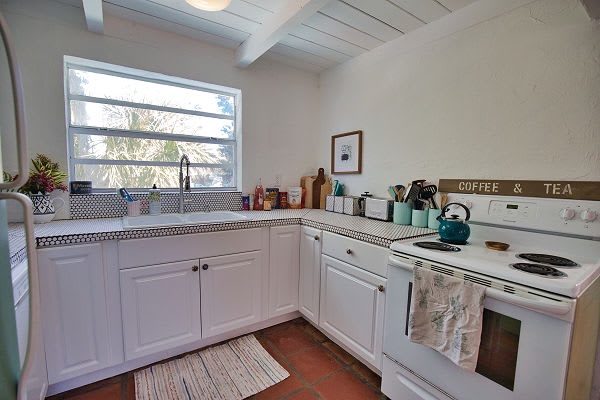 Whip up your morning coffee in this charming cottage kitchen, where exposed beams and bright windows create a cozy, welcoming space for your vacation meals.