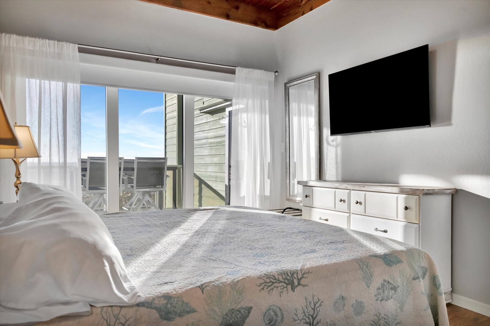 Wake up to warm sunlight streaming through your windows, where rustic wood ceiling details meet serene coastal style. Your private balcony awaits, promising fresh air and peaceful moments any time you need them.