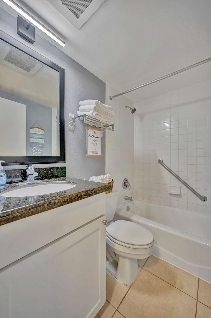 Step into your bright, freshly updated bathroom with crisp white subway tile, plush towels, and thoughtful touches like grab bars for extra comfort and safety.