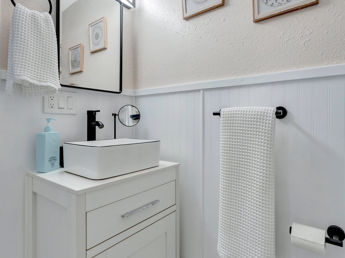Crisp white details and modern fixtures make this a refreshing space to start your mornings. The textured towels and sleek basin add a touch of comfort.