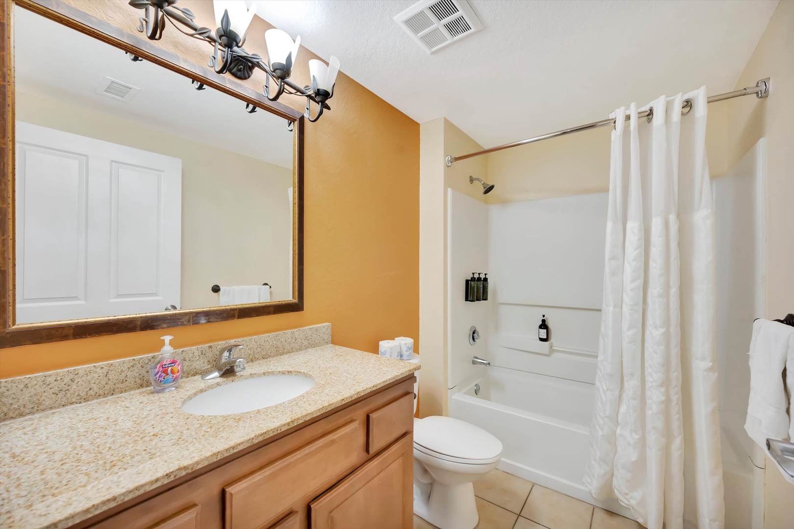Your full bathroom features warm lighting, ample counter space, and a convenient shower-tub combo for your comfort and ease during your stay.