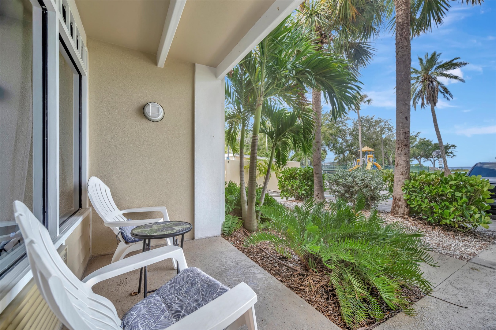 Step out to your private patio and unwind in the shade while tropical palms and lush greenery create a serene, resort-like escape just beyond your door.