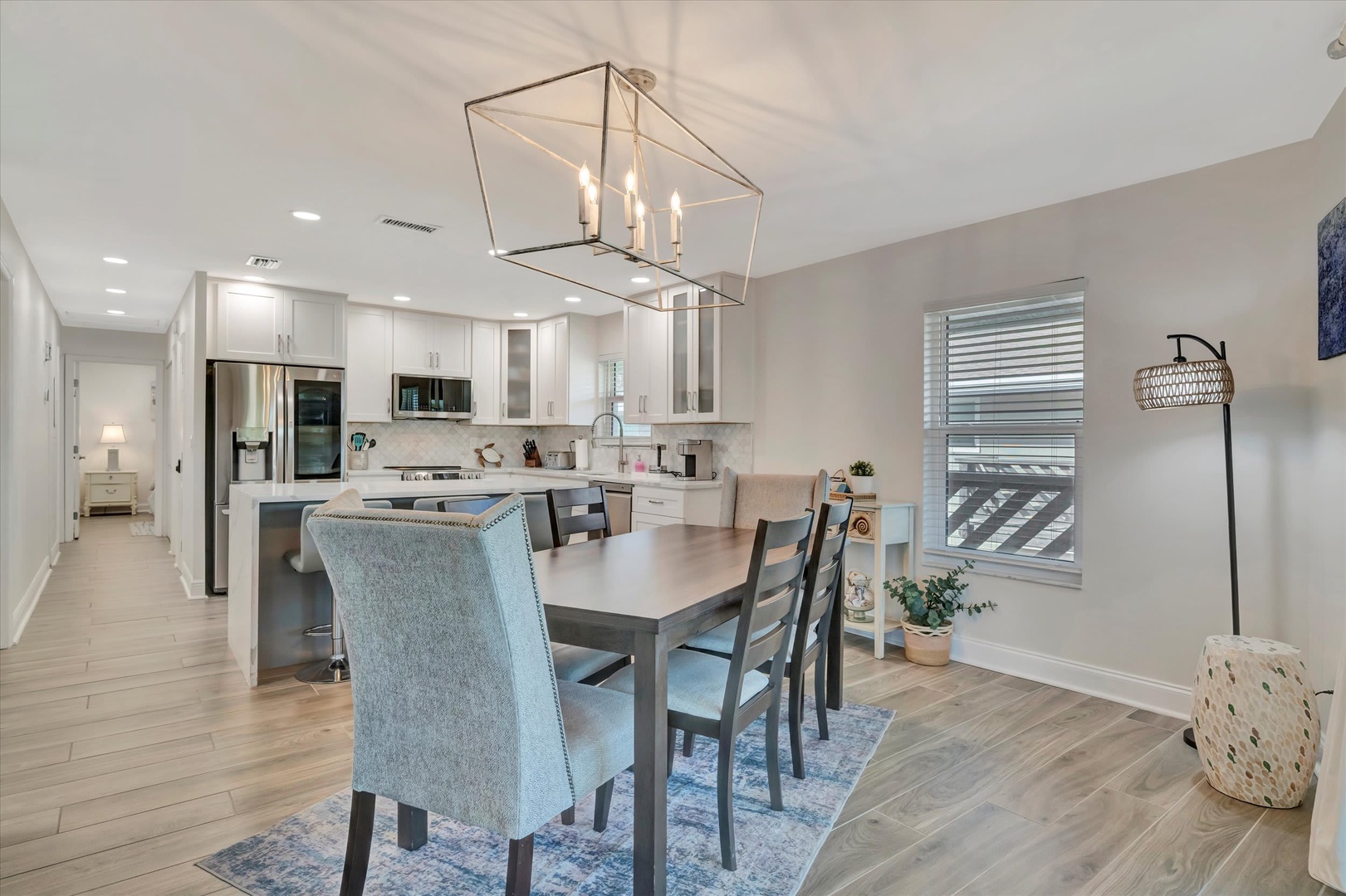 Gather around this bright, open dining space where elegant lighting and modern style set the stage for your shared meals and laughter. Natural light flows in, warming the welcoming atmosphere.