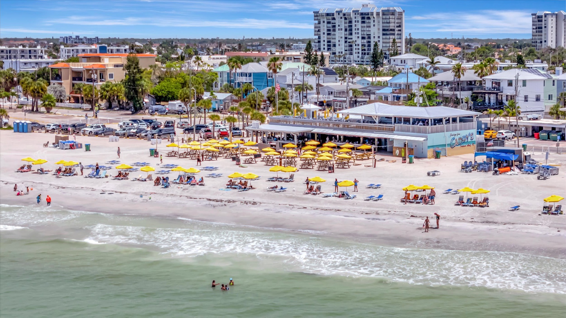 Aerial beachfront view in a vibrant coastal neighborhood with sandy shores, residential charm, and easy access to local attractions and beach amenities.