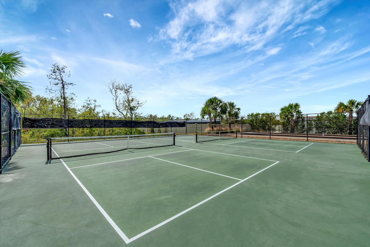 Pristine tennis courts await under sunny skies, surrounded by palms and natural landscaping—ideal for an active vacation day outdoors.