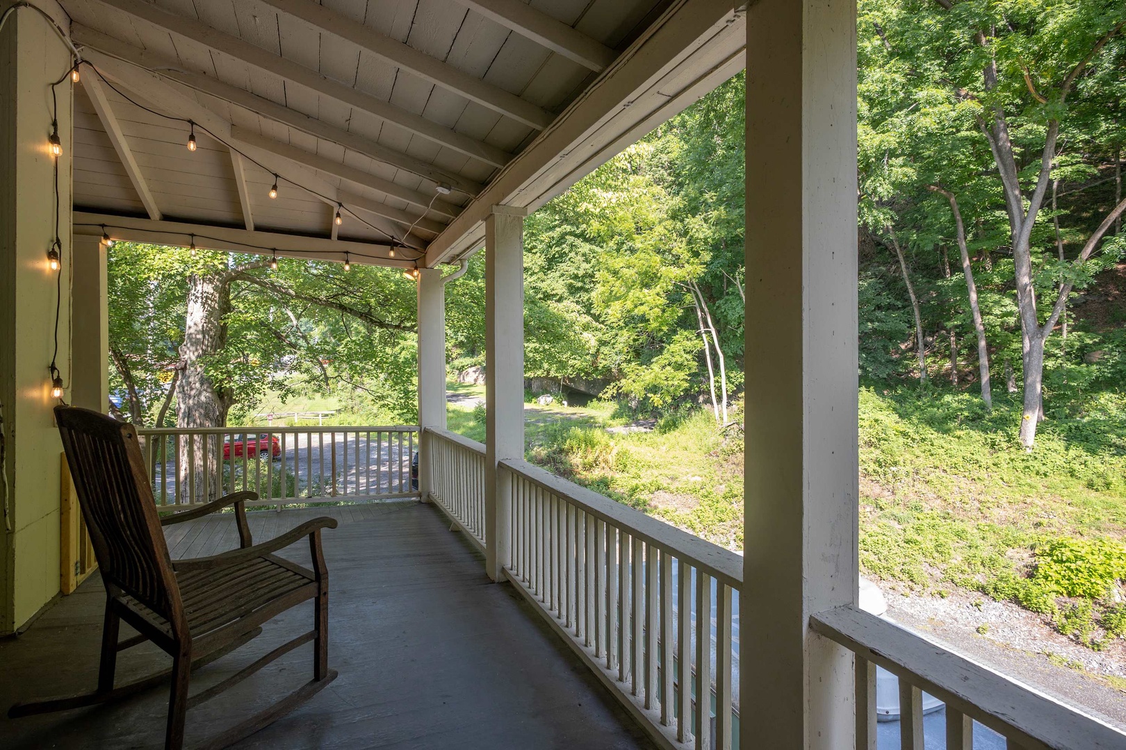 Unwind on your covered porch with warm string lights and peaceful forest views, perfect for quiet mornings or evening relaxation surrounded by nature.