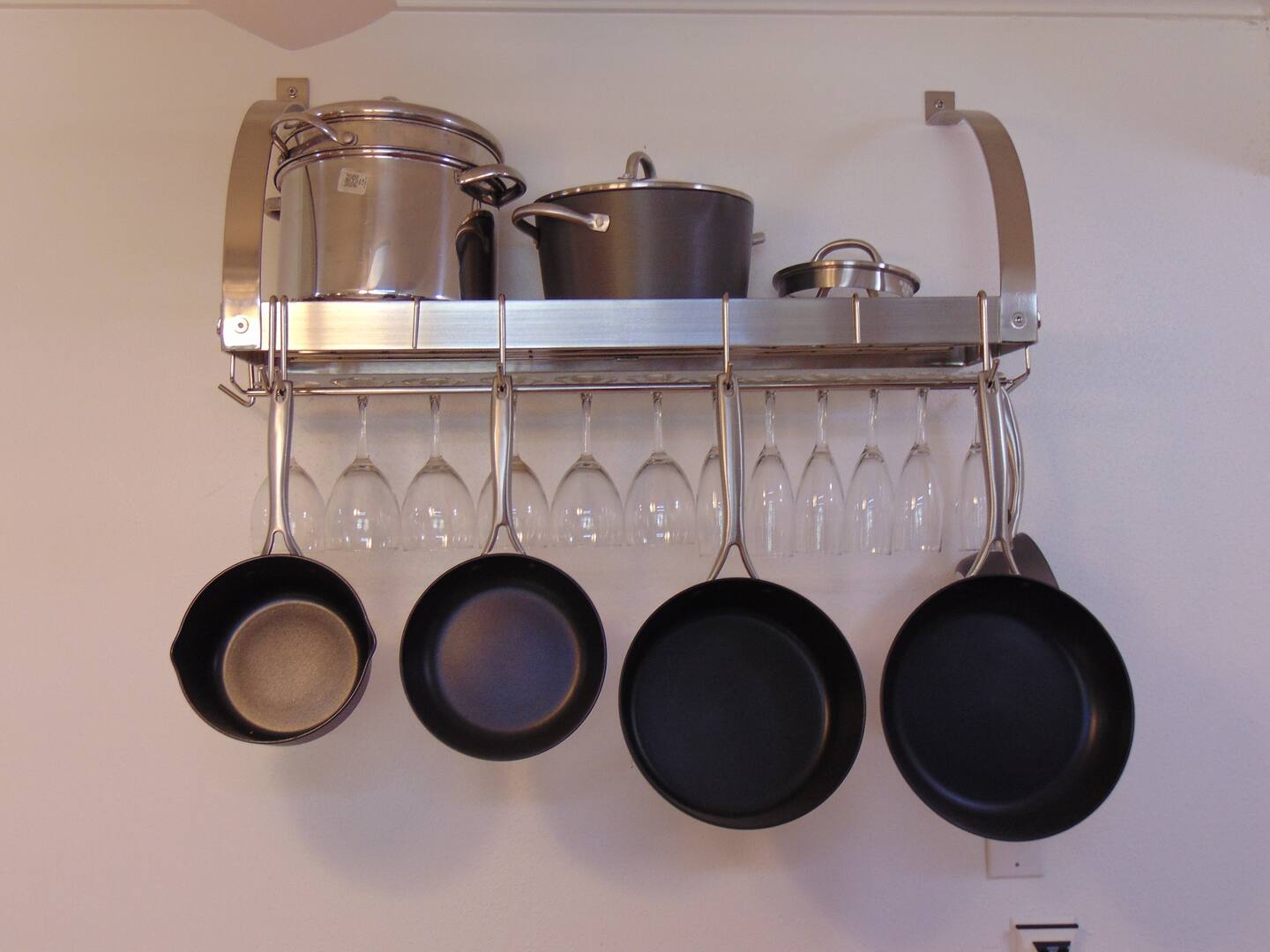 A practical wall-mounted rack keeps your cookware and stemware neatly organized and within easy reach while you prepare meals.