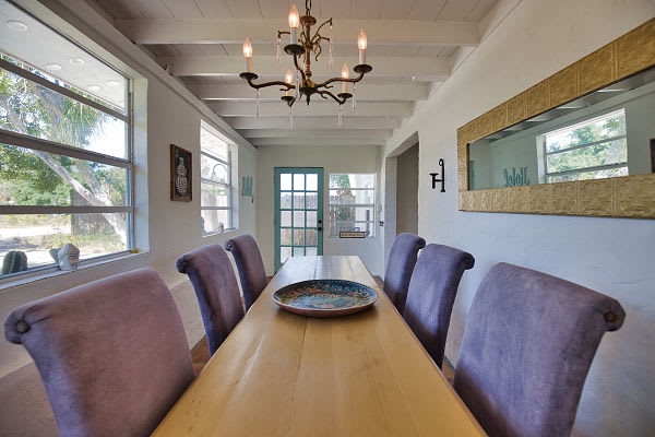Gather around this inviting dining table for meals and conversation, with natural light pouring through large windows and warm wood accents framing your retreat.
