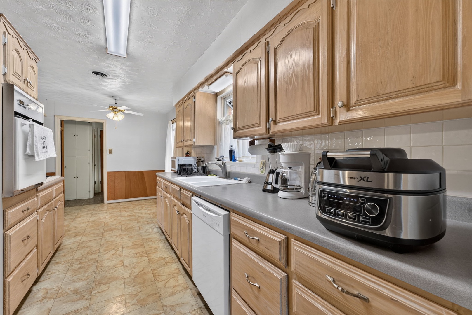 A spacious galley kitchen with warm oak cabinetry, ample counter space, and modern appliances—your home base for preparing meals and morning coffee during your stay.