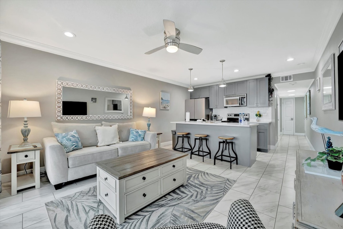 Settle into your inviting open-concept living space with soft coastal tones, comfortable seating, and a fully equipped kitchen ready for your meals. The airy layout and thoughtful details create a relaxing home base for your getaway.