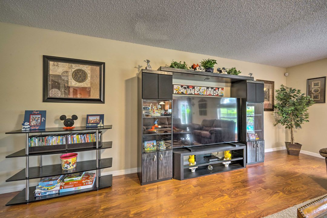 Your spacious living room features warm hardwood floors, ample storage for games and entertainment, and a large TV setup perfect for family movie nights and relaxation.