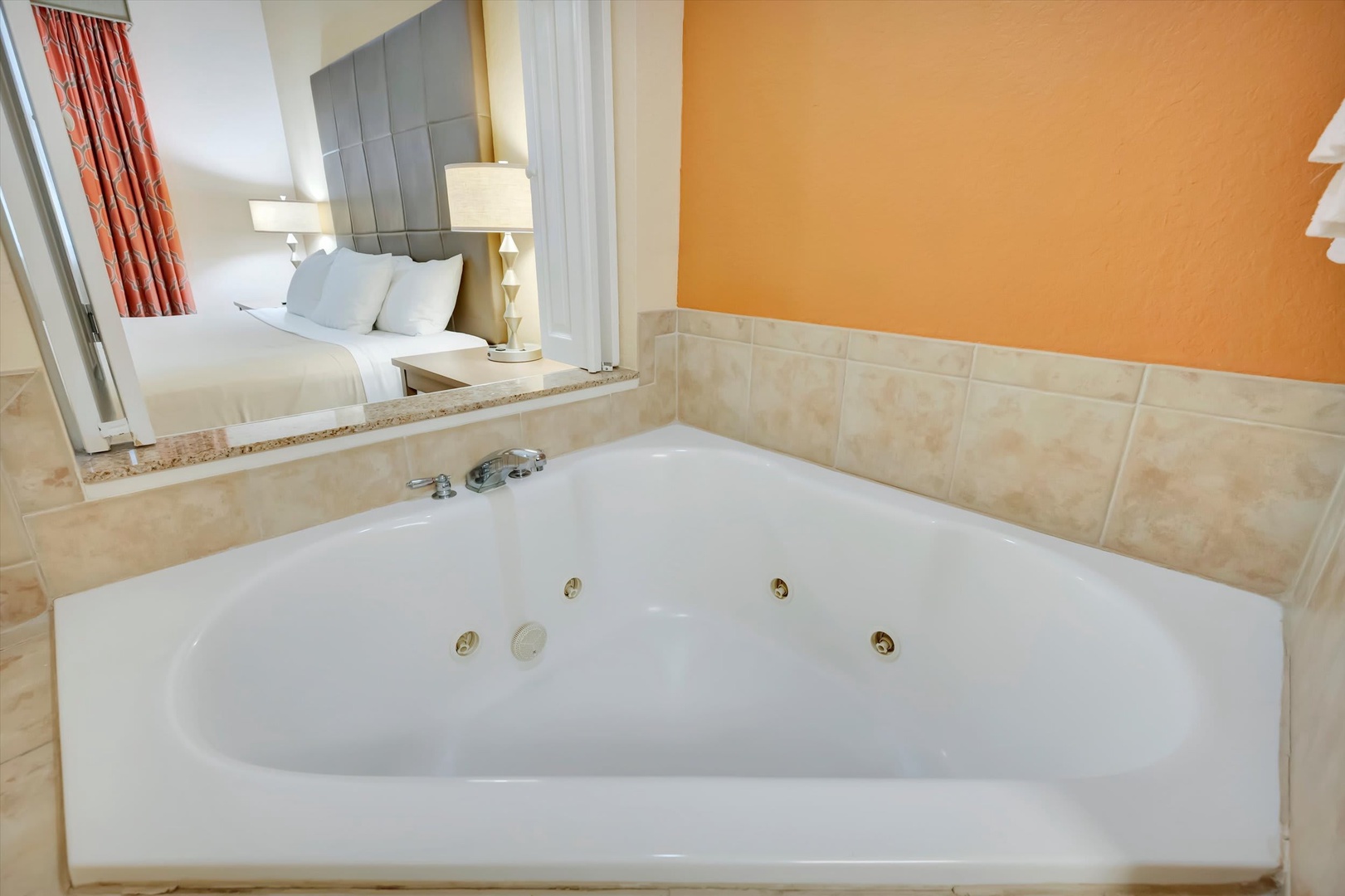 Unwind in your spacious jetted tub, perfectly positioned to glimpse your cozy bedroom beyond. The warm tones and thoughtful layout create an intimate retreat designed for pure relaxation.