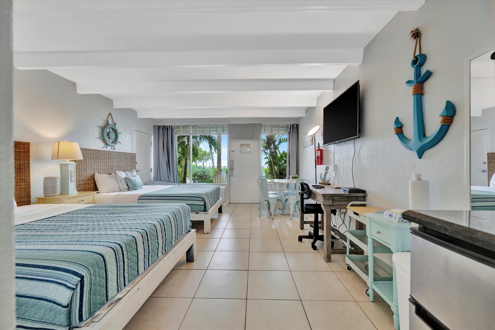 You'll love the coastal charm of this spacious room, with its nautical décor and twin beds dressed in calming blue tones. Bright tile floors keep everything cool, while lush palms sway just outside your windows.