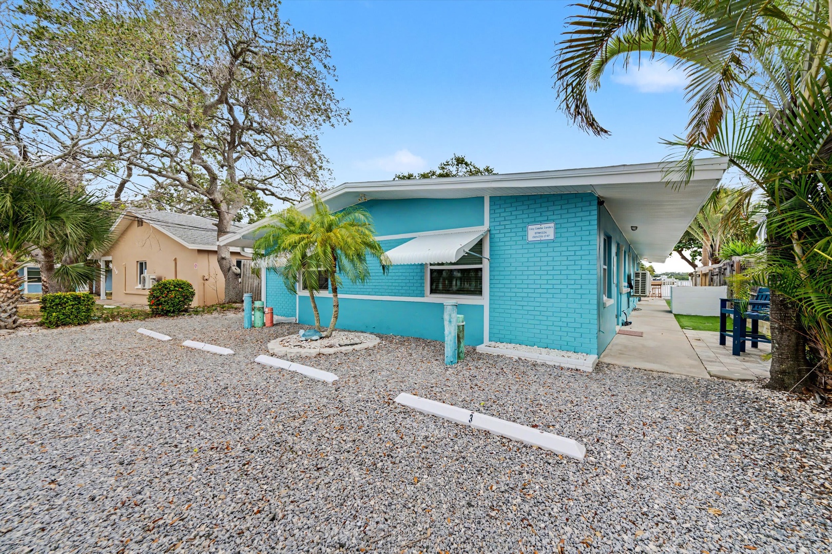 This cheerful turquoise bungalow sits tucked among tropical palms in a quiet neighborhood, offering easy access and a relaxed coastal vibe for your getaway.