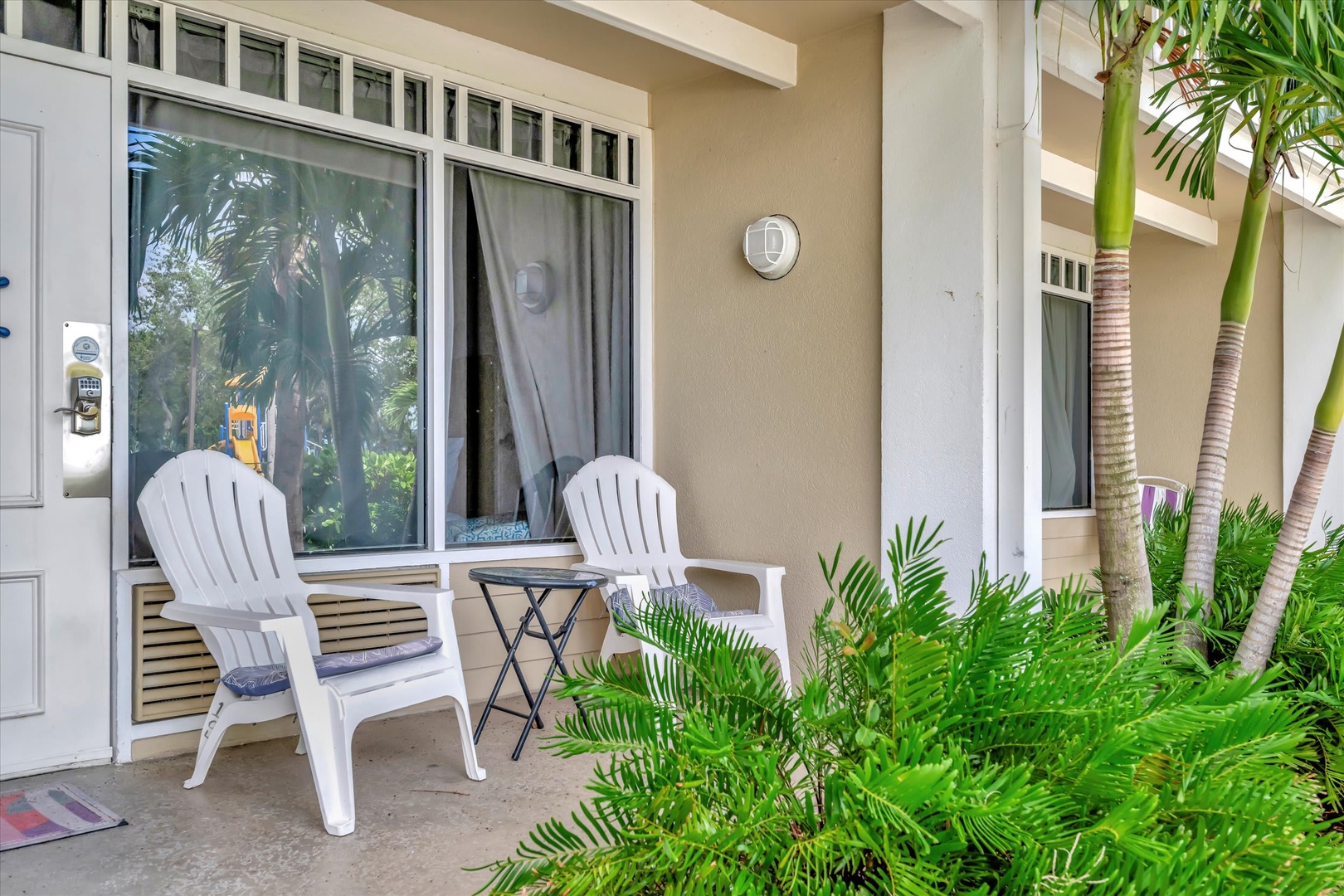 Your private patio invites you to unwind in cushioned Adirondack chairs, surrounded by lush tropical palms and just steps from your door.