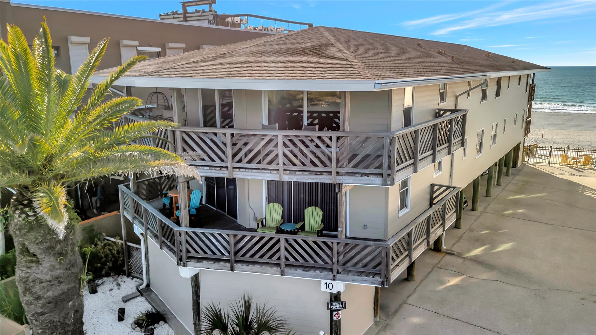 This beachfront property sits directly on the sand with ocean just steps away, featuring multiple balconies and tropical landscaping marking your coastal retreat.