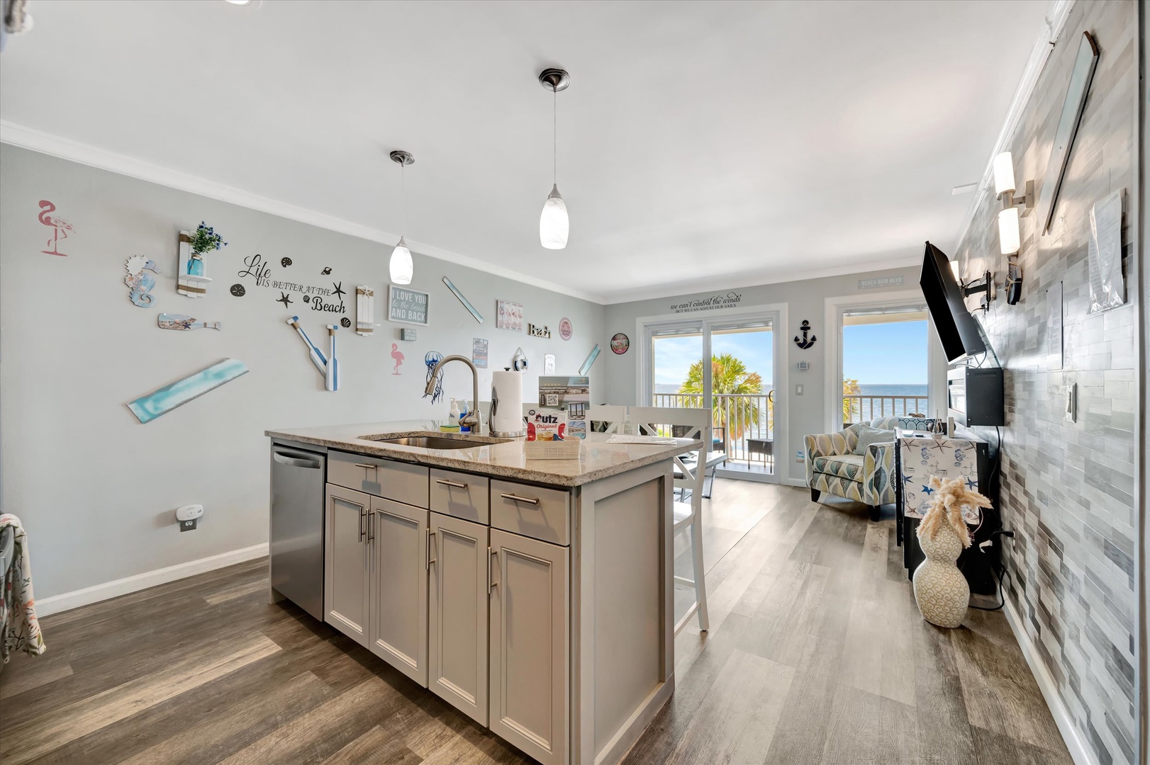 Step into your beach-themed kitchen where coastal breezes meet stunning ocean views through the balcony doors. The modern island, granite counters, and stainless appliances make meal prep a breeze while you soak in the sea air.
