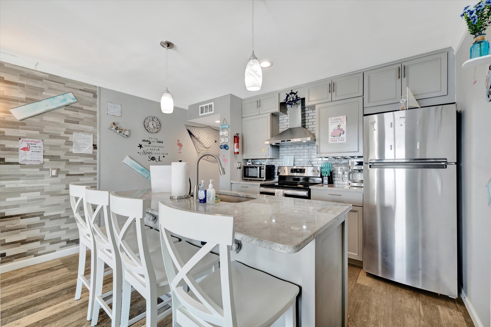 Your beachy-bright kitchen features modern stainless appliances, a convenient island with breakfast seating, and playful coastal decor that sets the tone for relaxed vacation mornings.