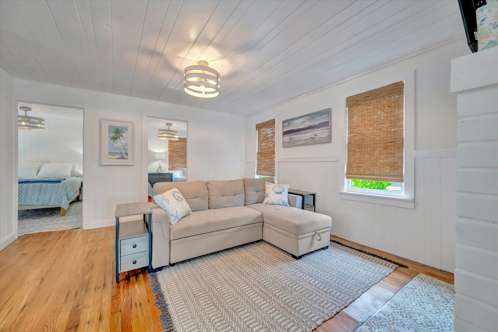 Settle into your bright, inviting living space featuring coastal-inspired décor and natural bamboo shades. The sectional offers plenty of room to unwind after a day of exploring.