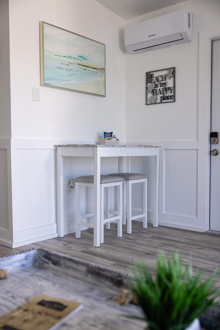 Your cozy breakfast nook awaits with beach-themed décor that sets the perfect vacation mood. Enjoy morning coffee at this charming marble-top bistro table while the AC keeps you comfortable in the coastal-inspired space.
