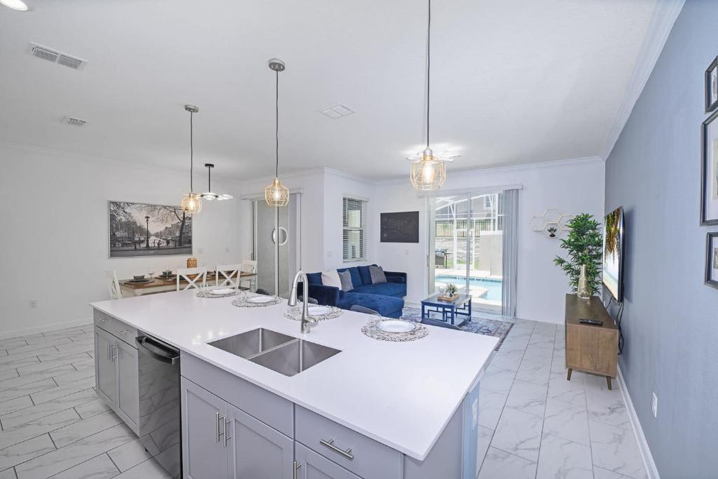 Step into a bright, open-concept space where your modern kitchen flows seamlessly into a living area overlooking the sparkling pool through floor-to-ceiling glass doors.